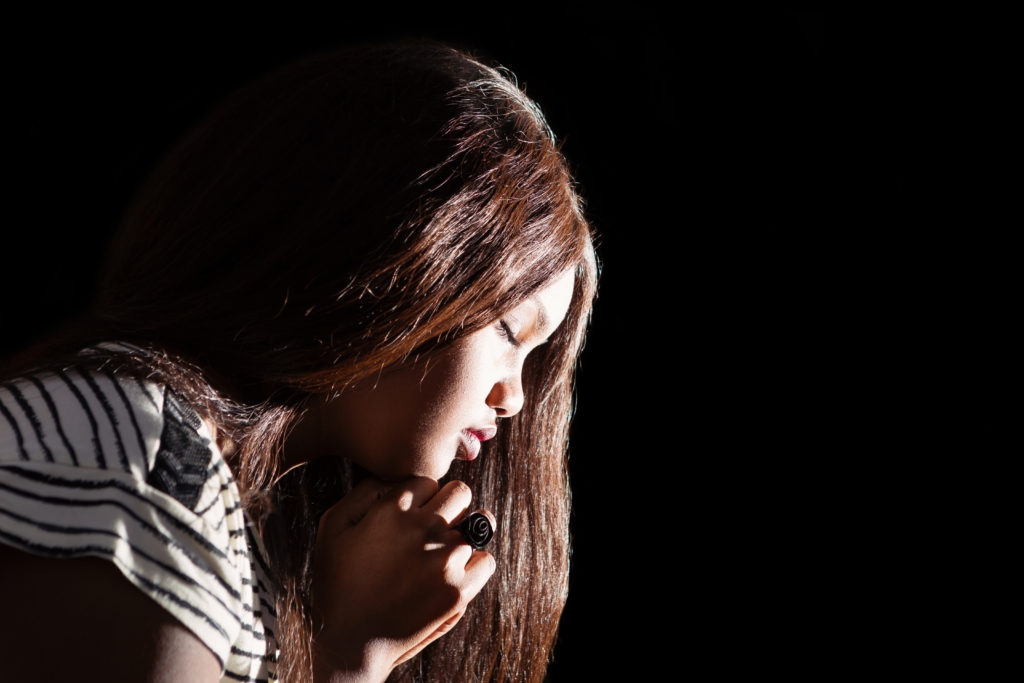 Young girl prays to do away with her worries and anxiety.