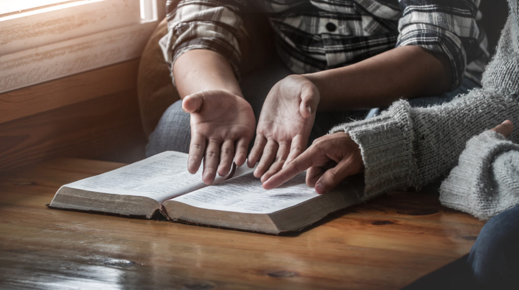 Man and woman discuss controversial section of the Bible so one will believe in Christianity 