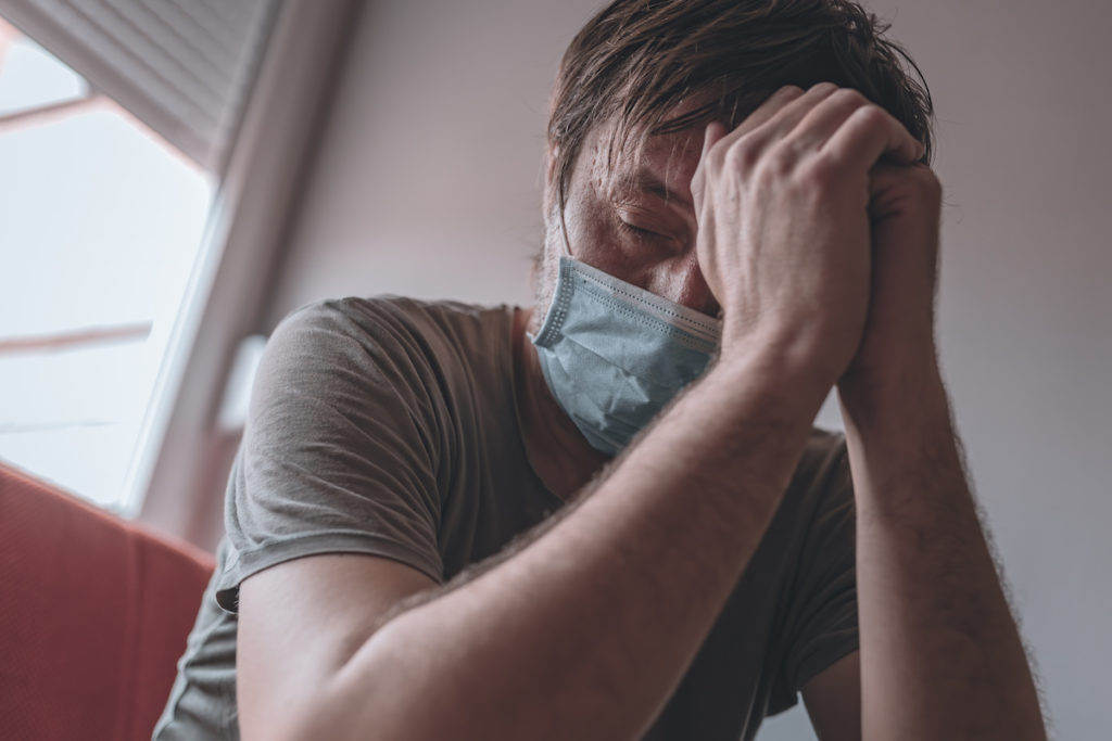 Worried stressed man self-isolated in home quarantine during covid-19 coronavirus pandemic, selective focus