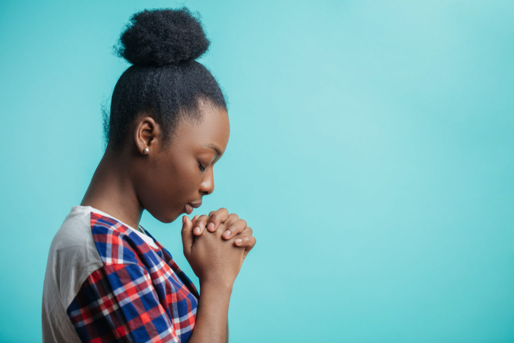 close up side view portrait of black girl with lively faith. expiatory faith.