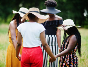 Women's ministry group holding hands and praying outdoors