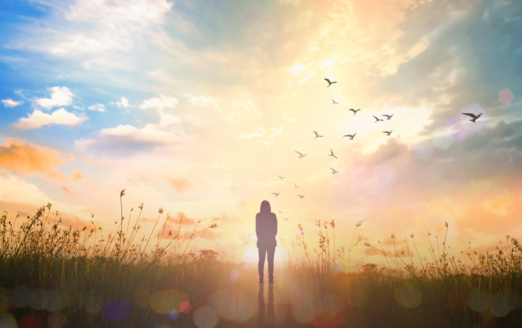 A Johnson City woman standing in a field at sunset.